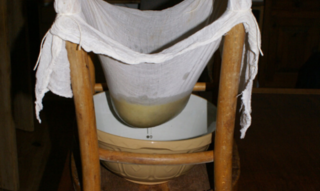 Straining jam with a muslin cloth and upside down chair