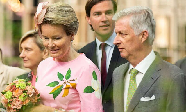 Queen Mathilde wore a degrade magnolia flower print belted poplin dress from Oscar de la Renta. Gold earrings and green pumps by Natan