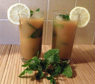 Two Glasses of Tea Garnished with Lemon and Mint