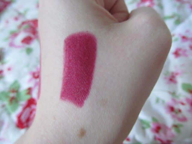 deep red lipstick swatched on white hand