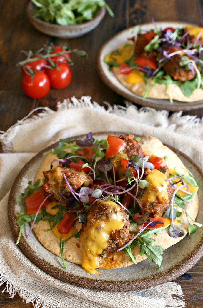 Recipe for meatballs flavored with taco seasonings such as cumin, chili powder and oregano. Served on tortillas.