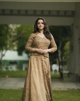 Bhavana Menon gracefully posing in a long, elegant dress during her latest photoshoot