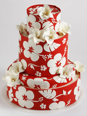  wedding cake made with red icing and covered in hibiscus sugar flowers