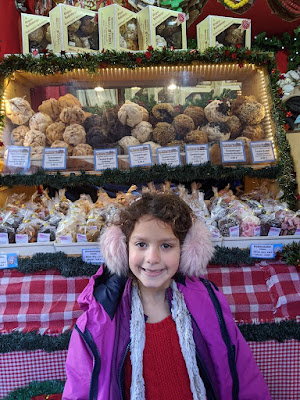 Little girl in front of European Christmas market pastries