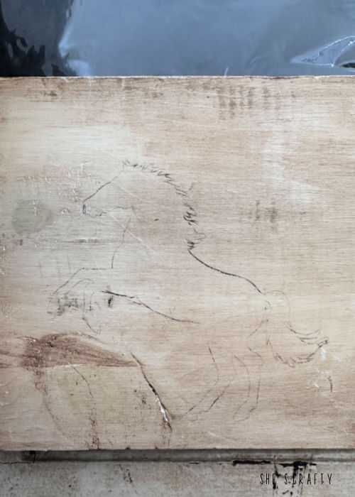 Traced horse on piece of wood.