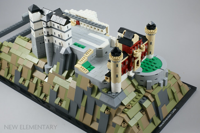 a view of the partially complete lego set with a small section of white tiles making three side of a rectangle surrounded by light bluish grey tiles representing the courtyard