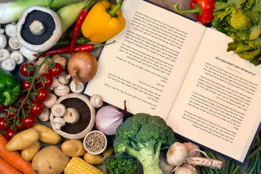צילום של ספר פתוח עם הטקסט של "דברים שהייתי רוצה לעשות בקיץ הזה". מסביב ירקות לבישול ותבלינים.