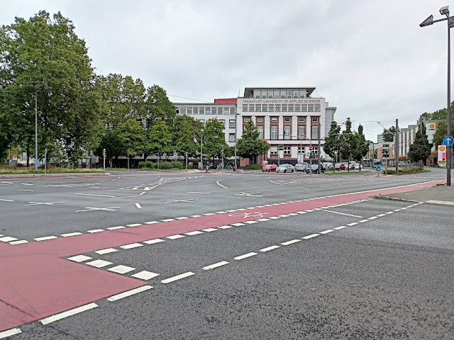 Ulica we Frankfurcie, wiele pasów, czerowe pasy dla rowerów, w oddali budynek uniwersytecki, wydział nauk przyrodniczych