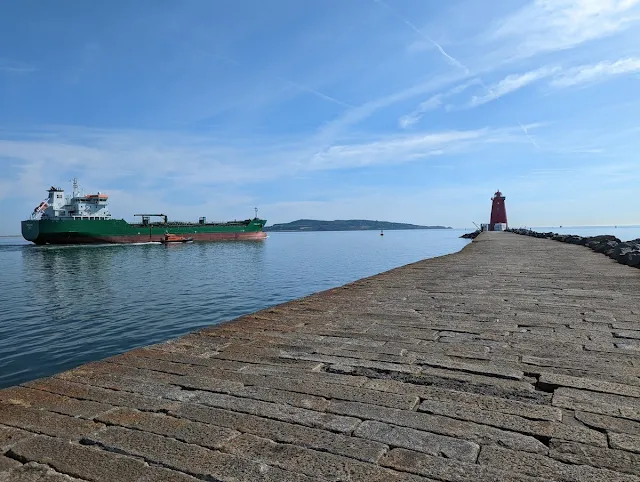 Path to Poolbeg Lighthouse and an incoming container ship in Dublin