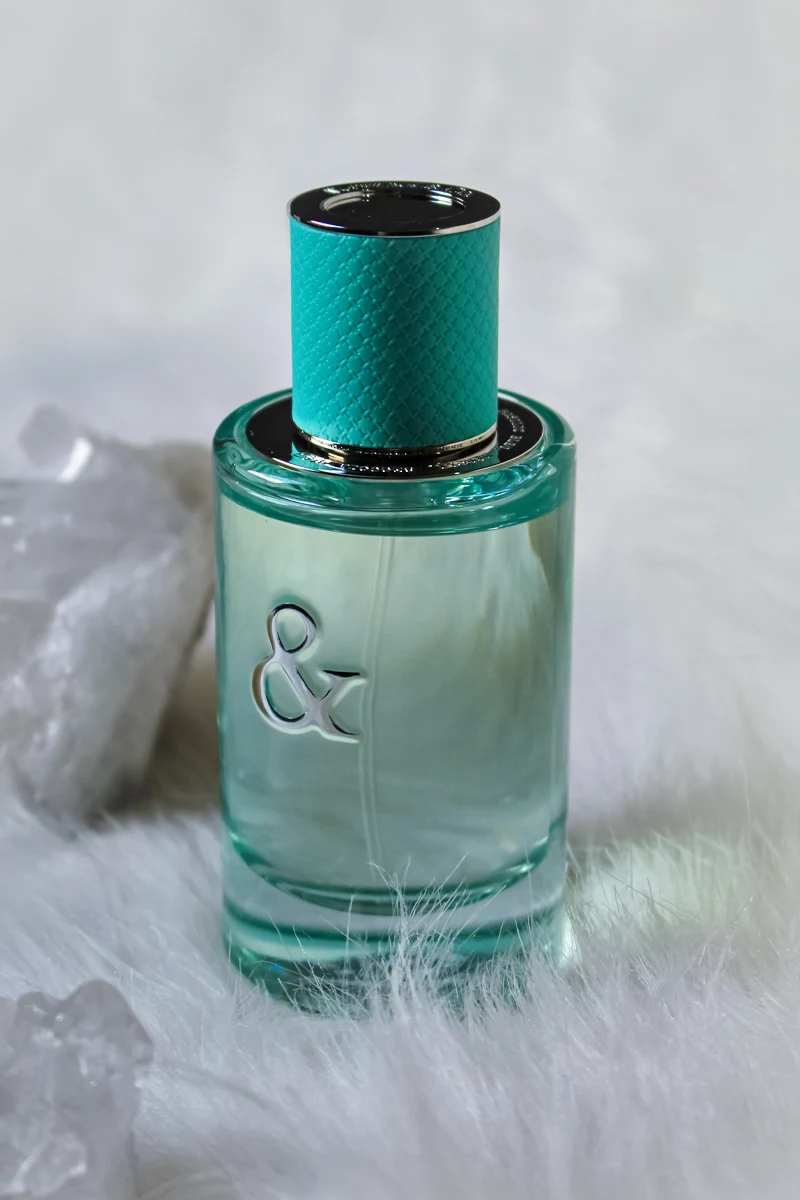 close-up studio shot of Tiffany & Co Love For Her Perfume tube on a white background surrounded by raw crystals