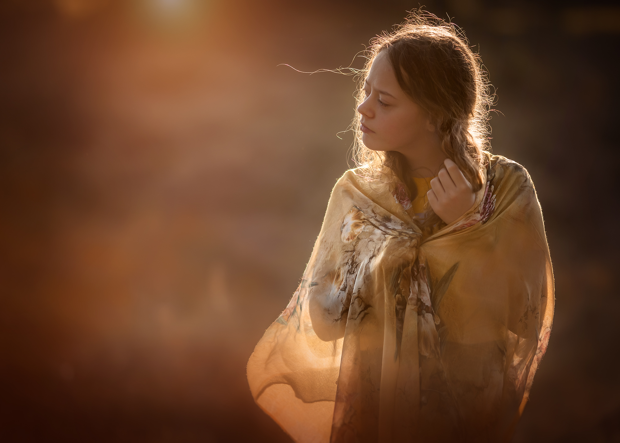Golden hour portret van een jonge vrouw met tegenlicht en een gele sjaal door natuurlijk licht fotograaf Willie Kers uit Apeldoorn
