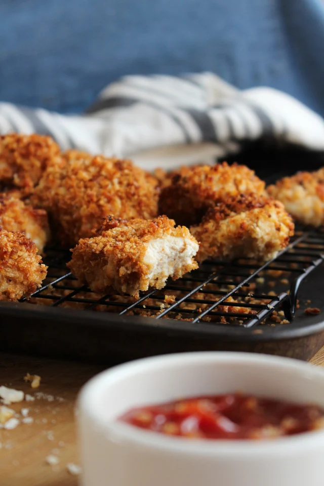 Crispy Parmesan Ranch Chicken Nuggets are dipped in ranch dressing, coated in a parmesan cheese and panko, and then baked in the oven for just 10 minutes until they are golden brown and extra crispy!