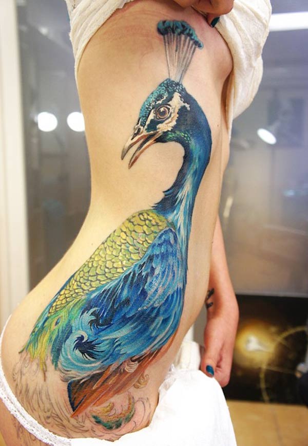 Wonderful girly peacock tattoo design on the side