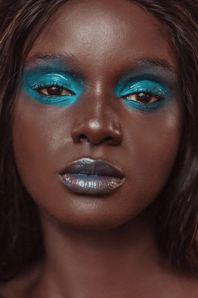 a portrait of a beautiful woman with a blue, mermaid-inspired makeup look