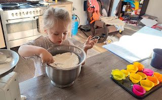 Rosie sifting flour as she bakes