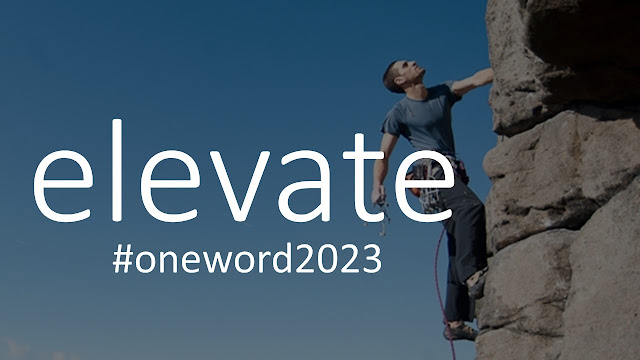 Photo of mountain climber on difficult rock face with the text, "one word 2023 - elevate"