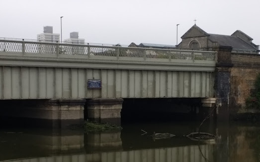 illegible plaque on the side of a bridge over Bow Creek