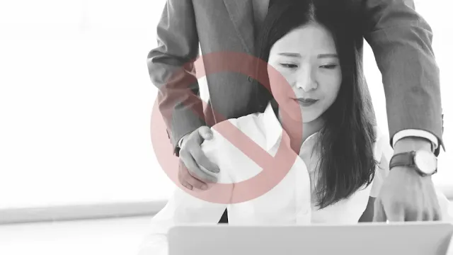 직장 내 성희롱으로 남자가 여자 어깨위에 손을 올리고 업무 지시를 하고 있다.