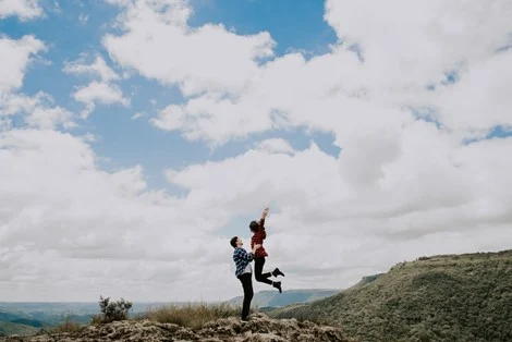 A man holding a woman as she jumps up