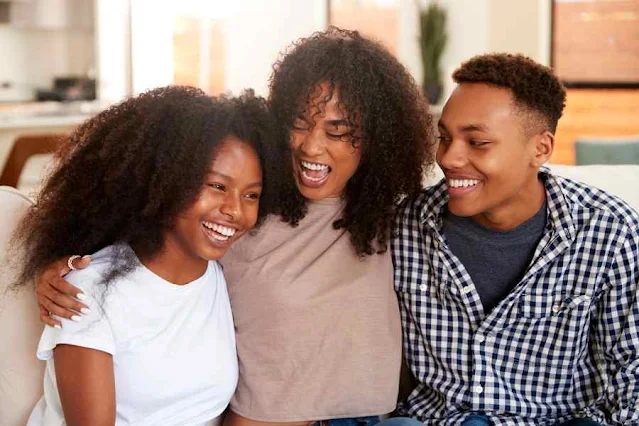 Teenage children hugging mother on sofa. Stock image from Canva Pro