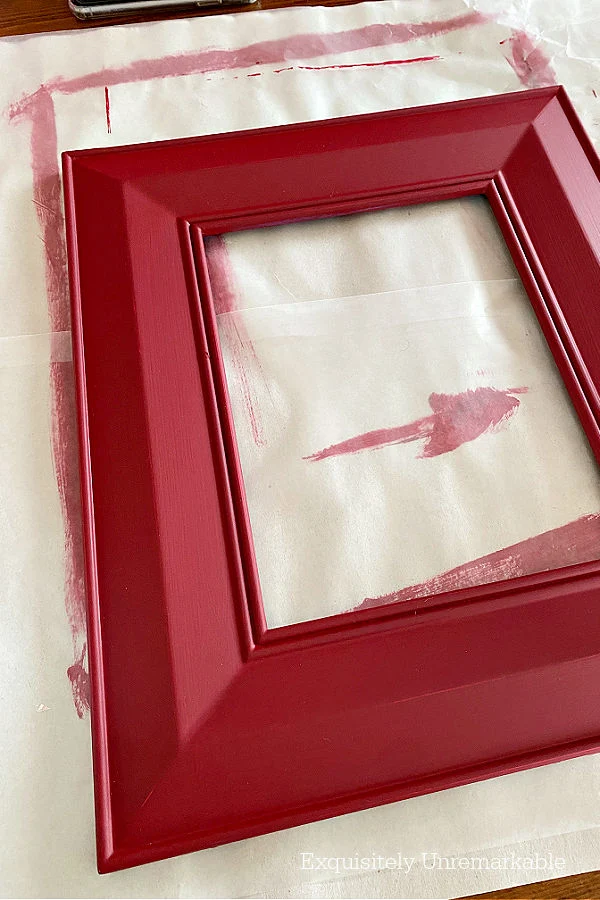 Adding a second coat of red chalk paint to a wood frame