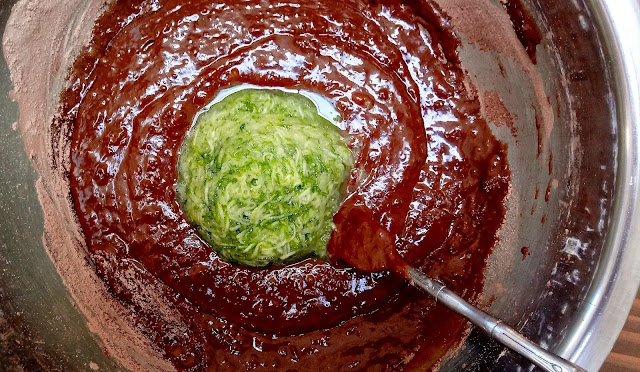 Chocolate Squash Banana Snack Cake Ingredients getting mixed in a large stainless steel bowl