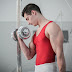 Male gymnast doing dumbbell bicep curls