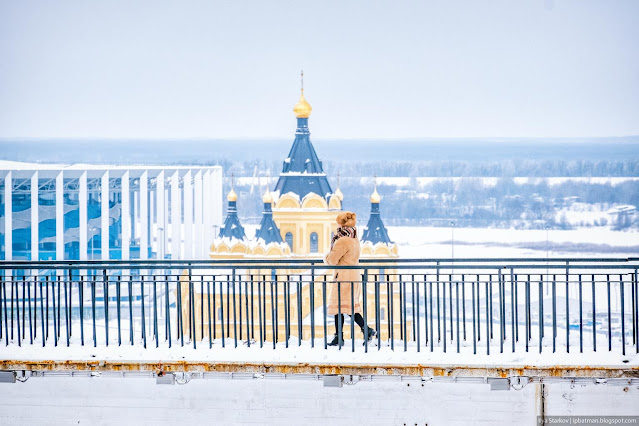 Девушка на пешеходном мосту на фоне Собора Александра Невского