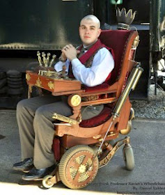 Man with shaved head sitting in a customized "steampunk" wheelchair