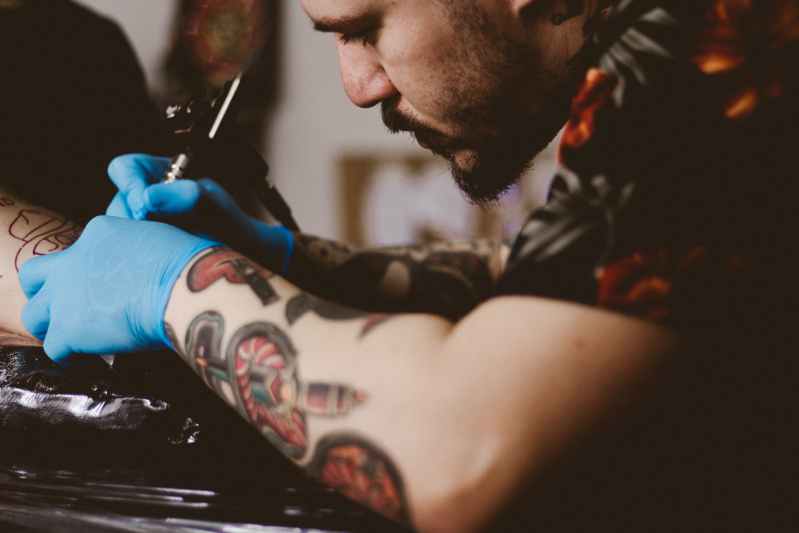 A man making a tattoo in male hand