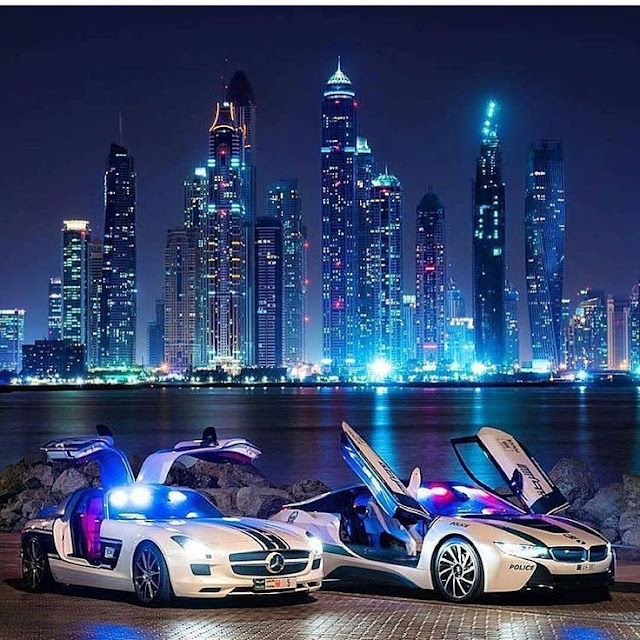 Two expensive cars on the shores of Dubai at night
