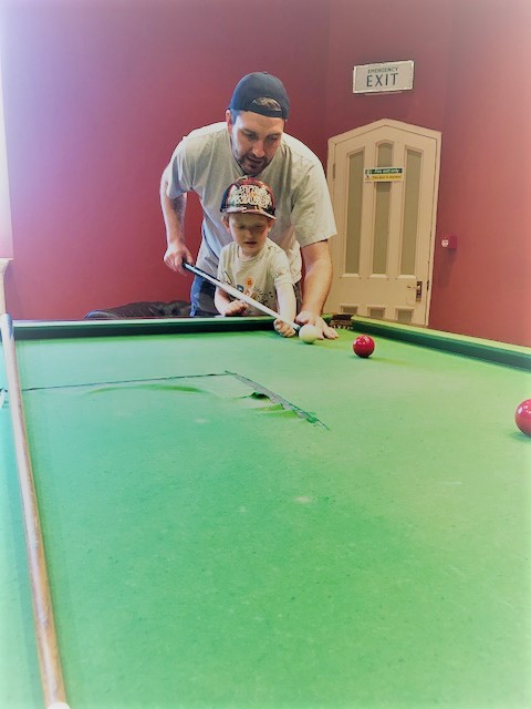 Daddy and son playing snooker