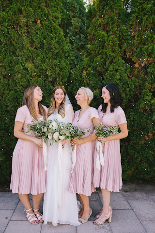 bridesmaids in blush holding olive leaf bouquets with a classic bride and her lush white bouquet for a white garden wedding in utah