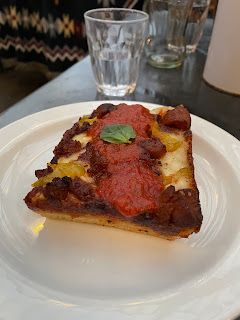 Slice of rectangular pizza on a dish.