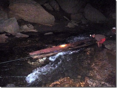 Konglor Cave - Moving the longboat through a shallow rapid