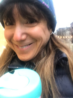 A selfie of me with a coffee cup on my morning walk in the city.