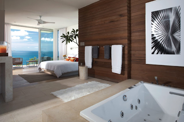 Modern bedroom and the ocean as seen from a bathroom