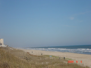 Can you find the fishing pier in this beach picture?