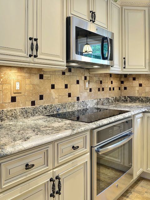 granite-countertop-travertine-glass-backsplash-tile-with-white-cabinets