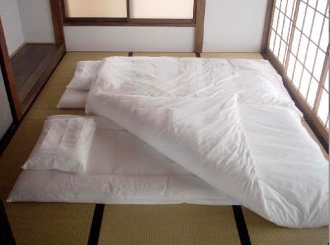 Futon mattresses spread out on tatami flooring. When you wake the ...