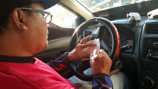 honest taxi driver manually writing a receipt for a trip from Iloilo airport to Ortiz wharf