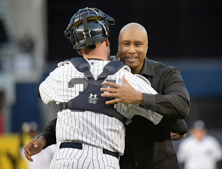 Bernie Williams, who won four World Series titles with the Yankees, with catcher Brian McCann after throwing a ceremonial pitch in the Bronx on Sunday.