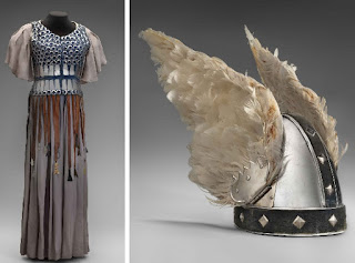 Photos. On the left, a long costume with a white cotton underdress and a scale-armor breastplate. On the right, a silver helmet with feathered wings.