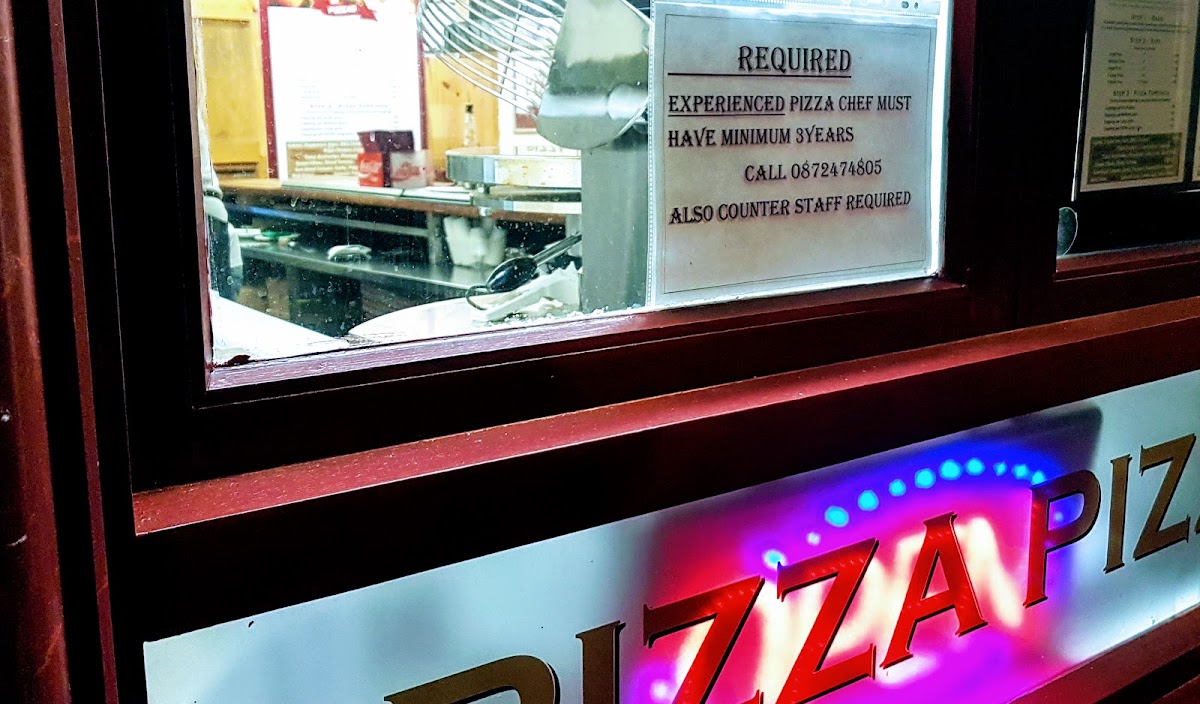 Pizza sign with back-lit flashing open sign style lighting - window into an Irish pizzeria 