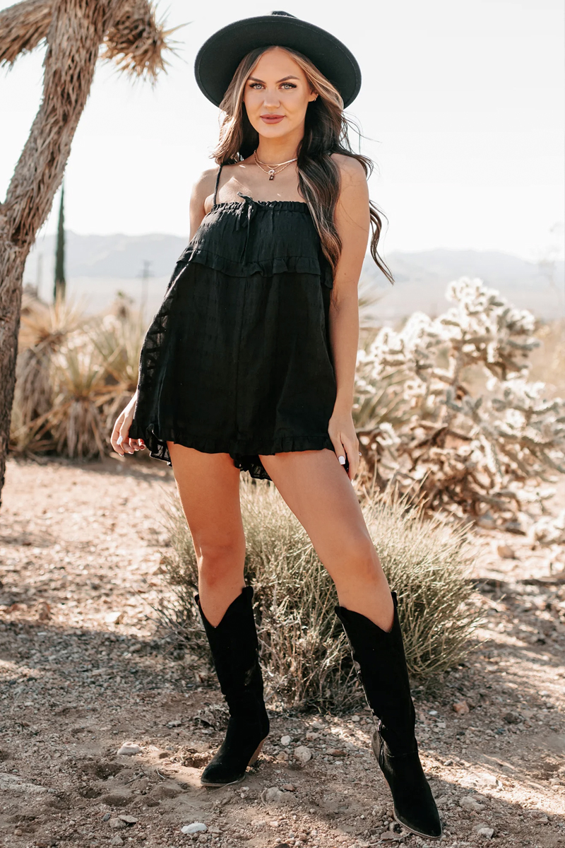 woman in a stylish total black look wearing lace romper