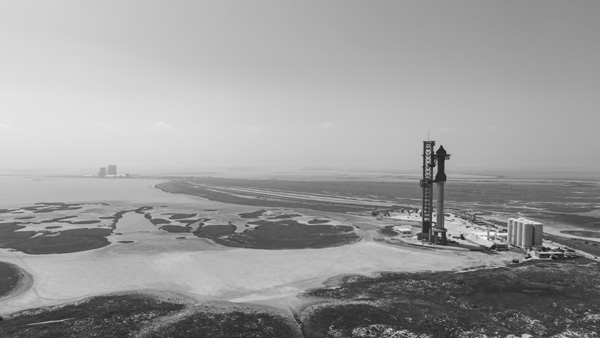 A black and white snapshot of Starship Super Heavy standing tall on its Orbital Launch Mount at Starbase, Texas...on April 15, 2023.