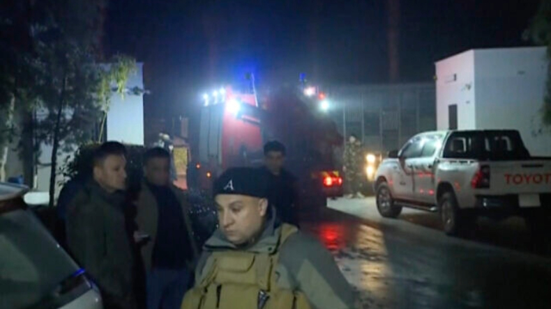 Esta imagem, capturada a partir de um vídeo fornecido pela Rudaw TV, mostra autoridades e outras pessoas nas proximidades do local onde mísseis atingiram uma área próxima ao consulado dos Estados Unidos em Erbil, Iraque, em 15 de janeiro de 2024 | Rudaw TV via AP