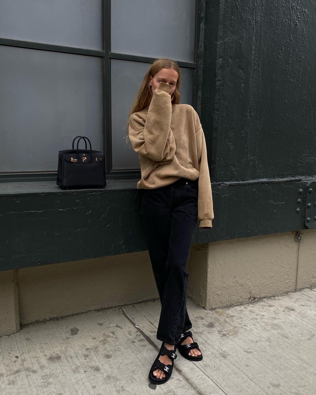25 Basic Yet Cool Sweatshirts to Shop Now — Instagram outfit idea — @mvb Marie von Behrens in a tan sweatshirt, an Hermès bag, black jeans, and Chanel dad sandals