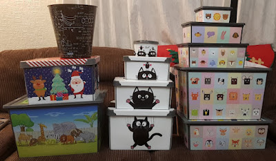 Maqio Storage Boxes with various designs cats animals Christmas Zoo all placed neatly in ascending order of size in 3 piles on a sofa