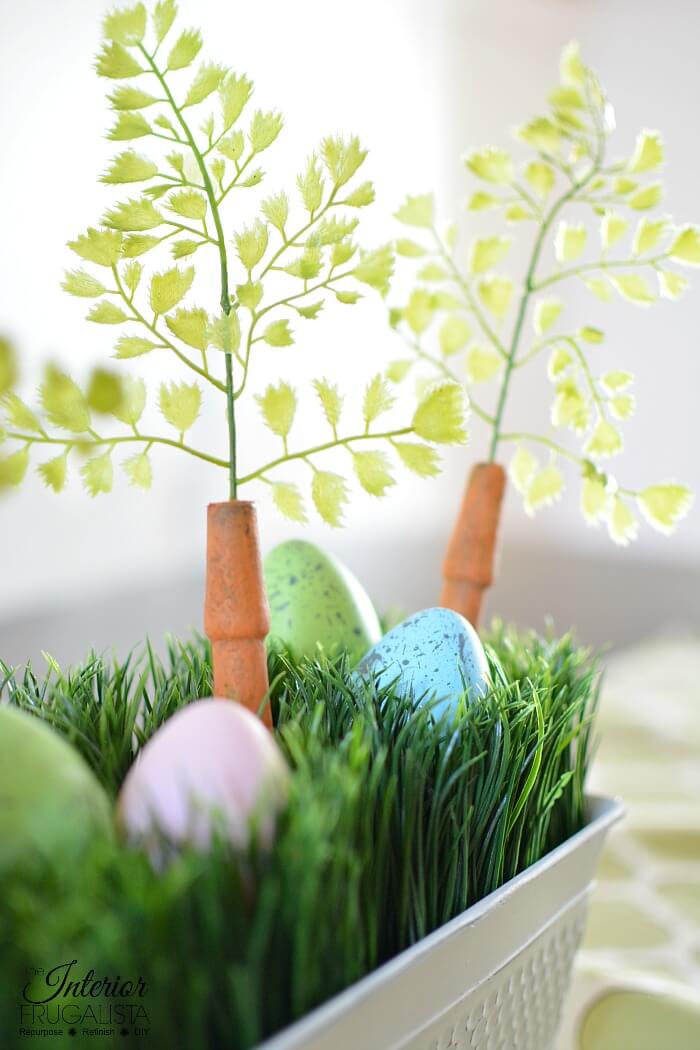 An upcycled Easter centerpiece box with faux wheatgrass, chair spindle carrots, and DIY speckled eggs for a fun budget Easter table decoration idea.